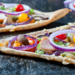 Flammkuchen in stukken gesneden belegd pizzatopping
